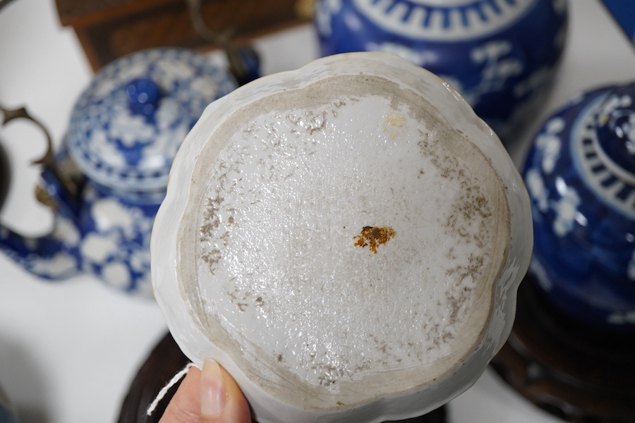 An 18th century Chinese blue and white dish, two jars (one without cover), a teapot and two carved wooden stands